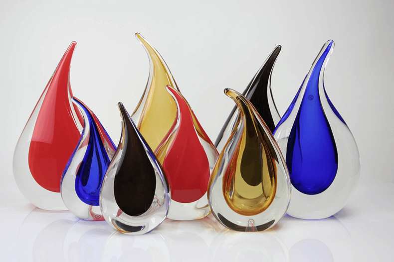 Flame shaped glass sculptures in red, blue, gold and black inside clear crystal